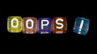 Word Oops. Black isolated cubes. Studio shot